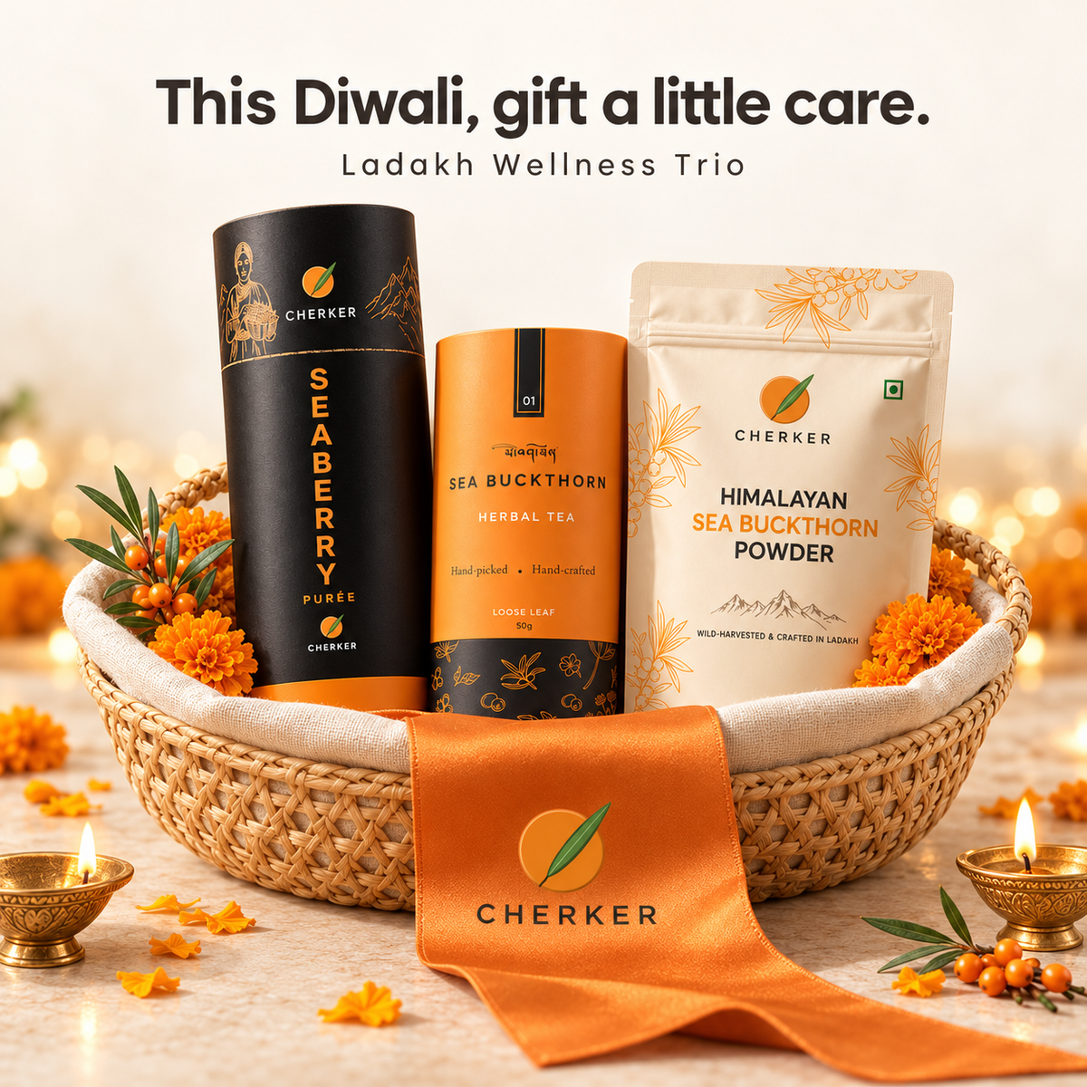 Cherker Ladakh Wellness Diwali trio gift basket with black Seaberry Purée tin, tea canister and Himalayan sea buckthorn powder pouch, orange ribbon and diyas